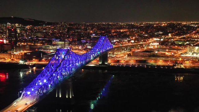 drone passing by the jacques cartier bridge at night