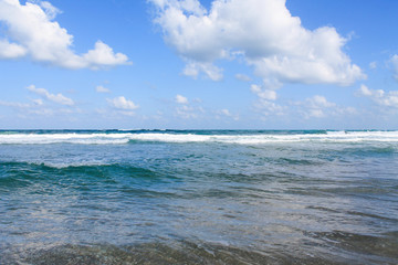 Fototapeta na wymiar Seashore at Bat Yam, Israel. Waves on the blue stormy sea. Mediterranean coastline. Travelling picture. Turquoise water and sandy beach