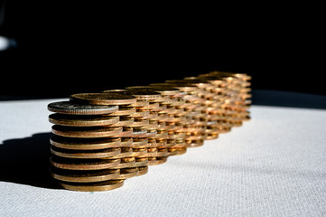 Stack of gold and silver dollar coins forming a border wall 