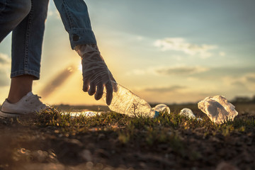 hand keeping garbage bottle for cleaning at park. eco concept