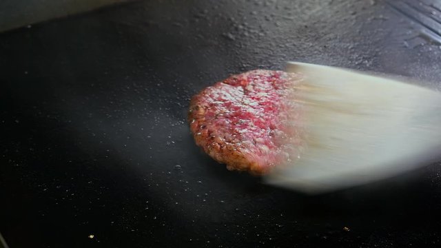 Timelapse chef fumbles on an electric grill cutlet for a burger with cheese