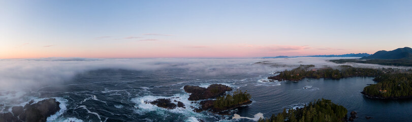 Fototapeta premium Ucluelet, Vancouver Island, British Columbia, Canada. Aerial Panoramic View of a Small Town near Tofino on a Rocky Pacific Ocean Coast during a cloudy and colorful morning sunrise.