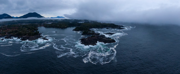 Ucluelet, Vancouver Island, British Columbia, Canada. Aerial Panoramic View of a Small Town near Tofino on a Rocky Pacific Ocean Coast during a cloudy sunrise.