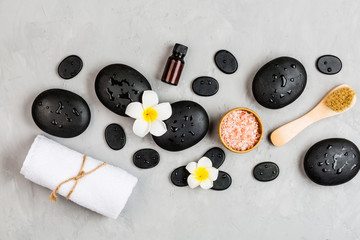 Top view of hot spa stones set for massage treatment on gray concrete background with copy space. Elegant and luxury spa. Flat lay, overhead, mock up, template. Health and beauty care concept
