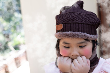 Portrait of a cute little girl in a wool hat at the weather is cold