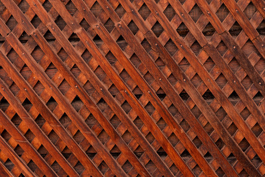 Brown wooden wall lattice background texture.  wooden fence cross pattern. Crossing a tree with nails.