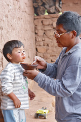 Native american man feeding his little son in the countryside.