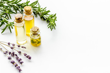 Aromatherapy. Essential oils in small bottles near fresh herbs on white background copy space - obrazy, fototapety, plakaty