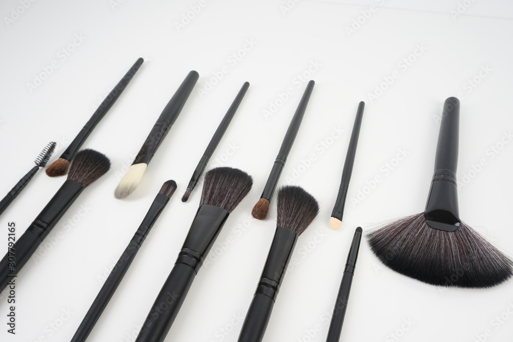 Wall mural A set of a black make up brushes over the white background