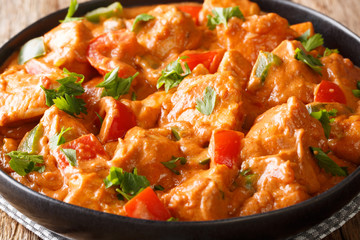 Spicy chicken mafe in peanut sauce, with tomatoes, pepper and coconut milk close-up in a plate....