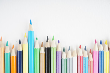 Rainbow colour pencils on the white paper over the white background