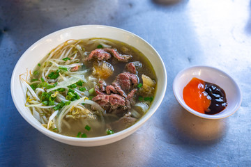 Bowl of beef noodle soup served with bean sprouts