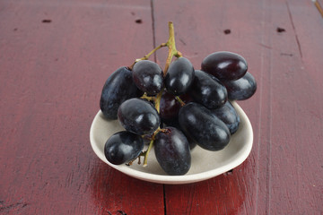 Fresh grape fruits plated over the wooden background