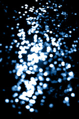 Black background with classic blue bokeh lights. Holiday, Christmas and New Year background. Horizontal