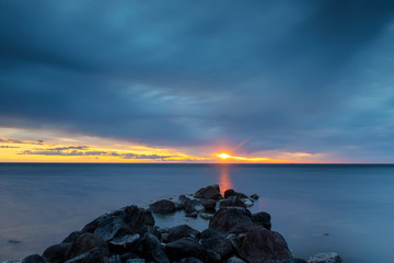 Dark grey storm clouds over ocean horizon during sunset over the Baltic Sea at island of Gotland, Sweden