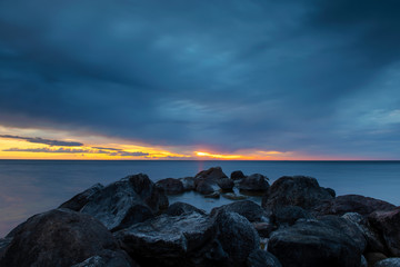 Dark grey storm clouds over ocean horizon during sunset over the Baltic Sea at island of Gotland, Sweden