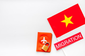Migration to Vietman concept. Vietnamese flag near passport and lock on white background top-down copy space