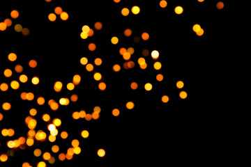 Fototapeta na wymiar Black background with bright warm bokeh lights. Holiday, Christmas and New Year background. Ideal to layer with any design. Horizontal