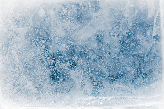 Textured, blue toned, ice block surface with hoar frost, background.