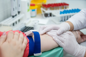 Close up of doctor arms sticking needle into male arm for blood sampling