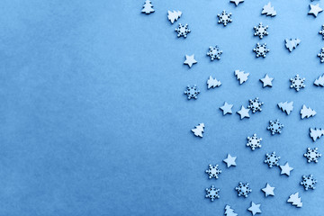 Small wooden Christmas trees and snowflakes in classic blue color.