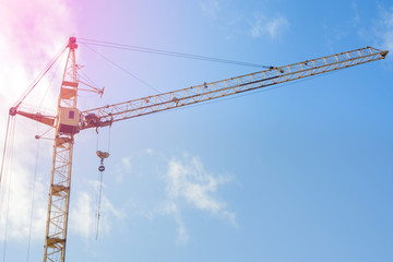 Construction crane close-up, against the blue sky. Concept of building construction, place for text, copy space