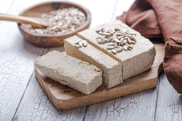 Sunflower halva with seeds  on wooden background. Festive Oriental delicacy