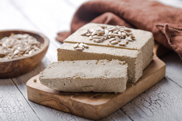 Sunflower halva with seeds  on wooden background. Festive Oriental delicacy