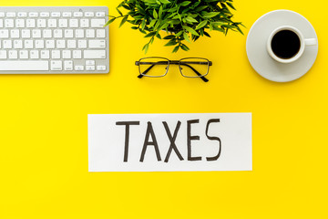 Taxes text on yellow office background top view