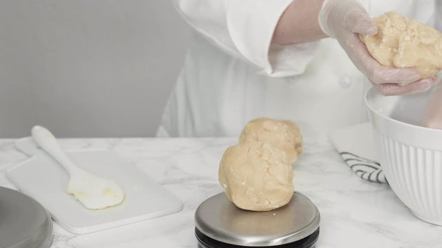 Step by step. Measuring cookie dought with a digital kitchen scale to bake red, white, and blue pinwheel sugar cookies.