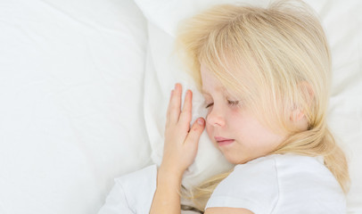 little girl sleeping on her bed