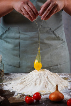 Chef Cracking An Egg In The Flour