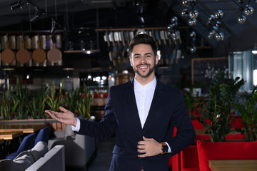 Young business owner standing in his cafe