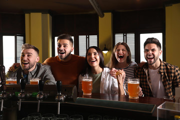 Group of friends watching football in sport bar