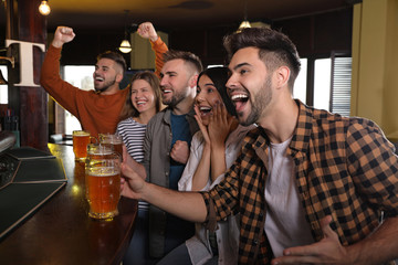 Group of friends watching football in sport bar