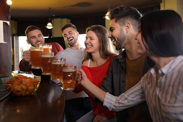 Group of friends celebrating victory of favorite football team in sport bar