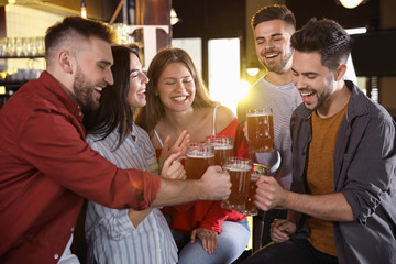 Group of friends celebrating victory of favorite football team in sport bar