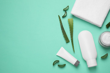 Flat lay composition with aloe vera and cosmetic products on turquoise background. Space for text