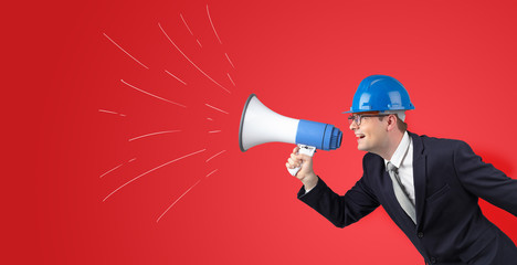 Fototapeta premium Young architect constructor yelling with megaphone and copyspace