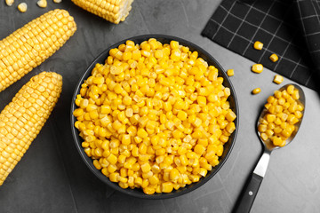 Delicious canned corn in bowl on grey table, flat lay