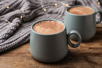Cups of delicious hot cocoa on wooden table