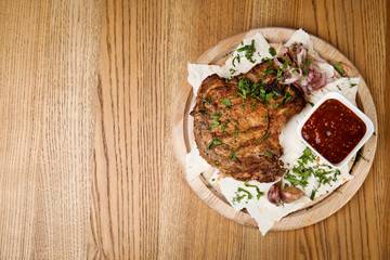 Delicious grilled pork chop served on wooden table, top view. Space for text