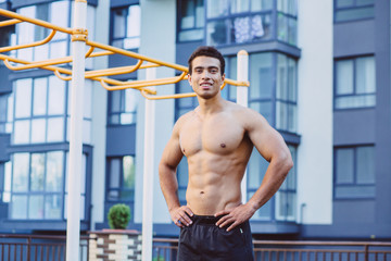 Sportsman resting on sportsground after workout. Athlete man looking away, relaxinf after exercises. Sport, lifestyle and people concept.