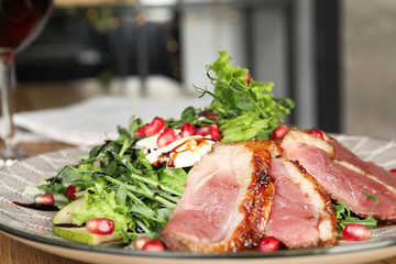 Delicious salad with roasted duck breast on plate, closeup