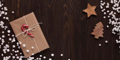 Christmas composition made of Gift box and christmas decor on a wooden brown background.