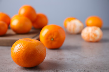Fresh ripe tangerine on grey table. Space for text