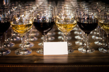 Glasses of wine on the bar with a neutral business card.