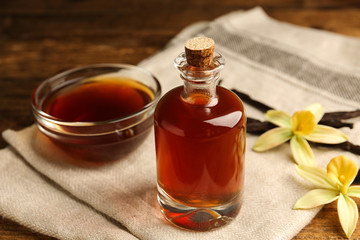 Aromatic homemade vanilla extract on wooden table