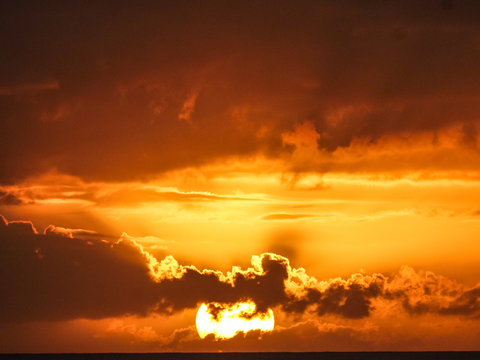 sun behind dark clouds