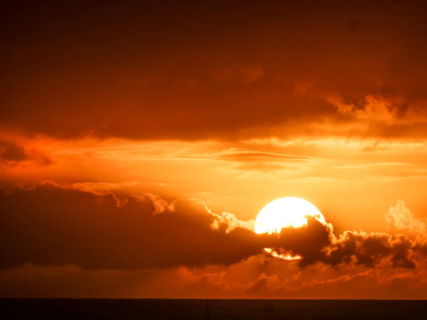 sun behind dark clouds